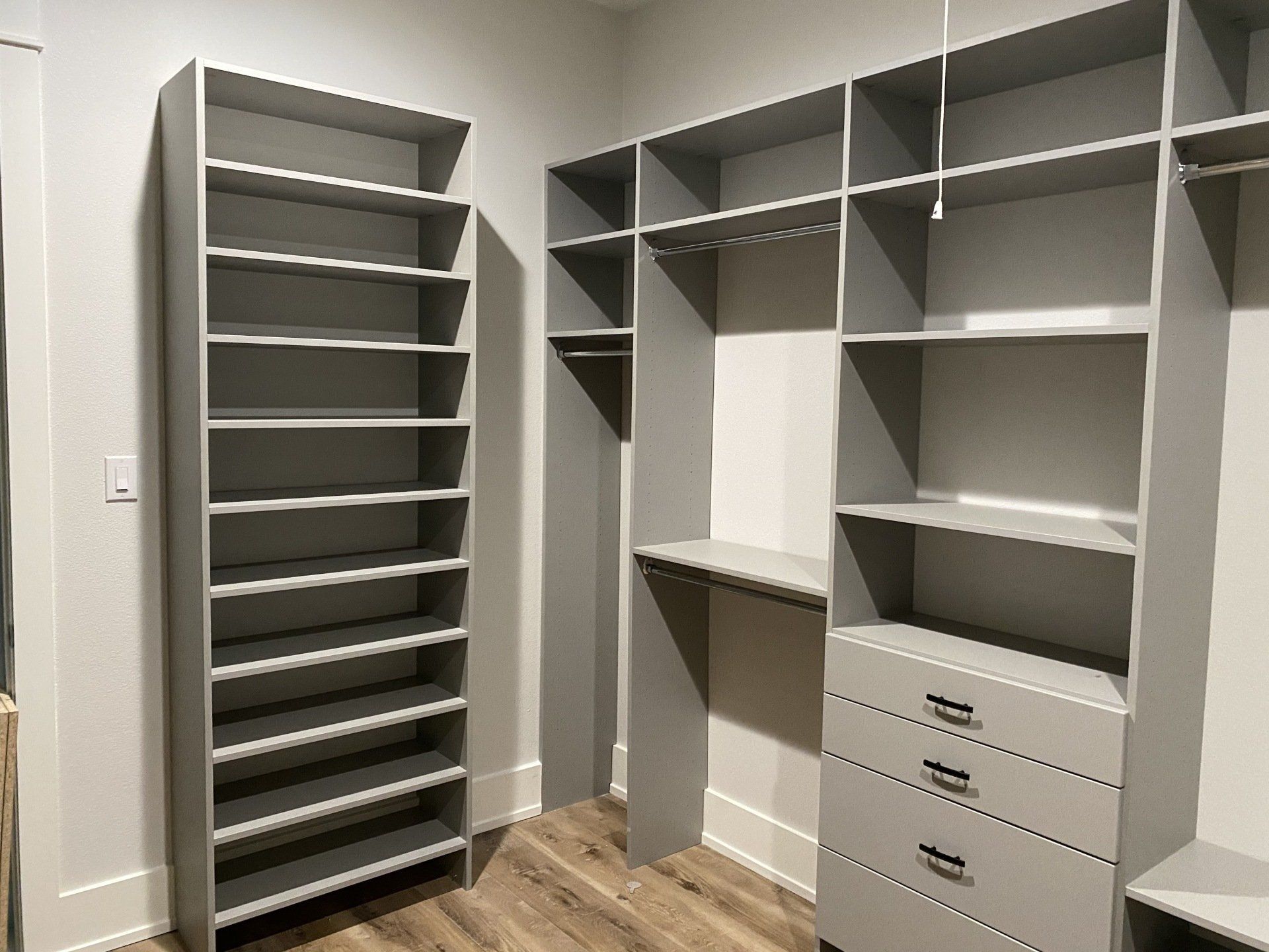 A walk in closet with lots of shelves and drawers.