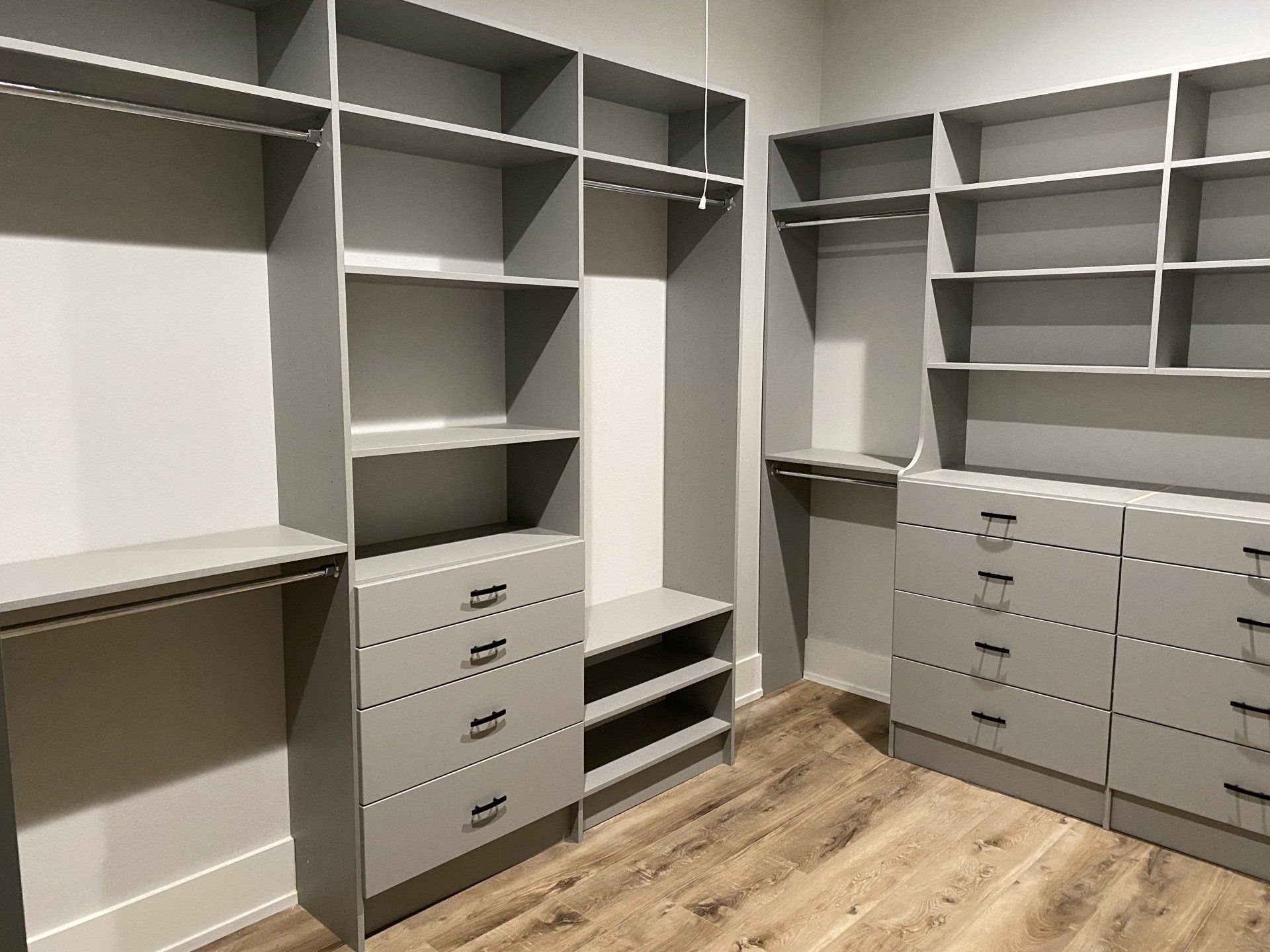 A walk in closet with lots of shelves and drawers