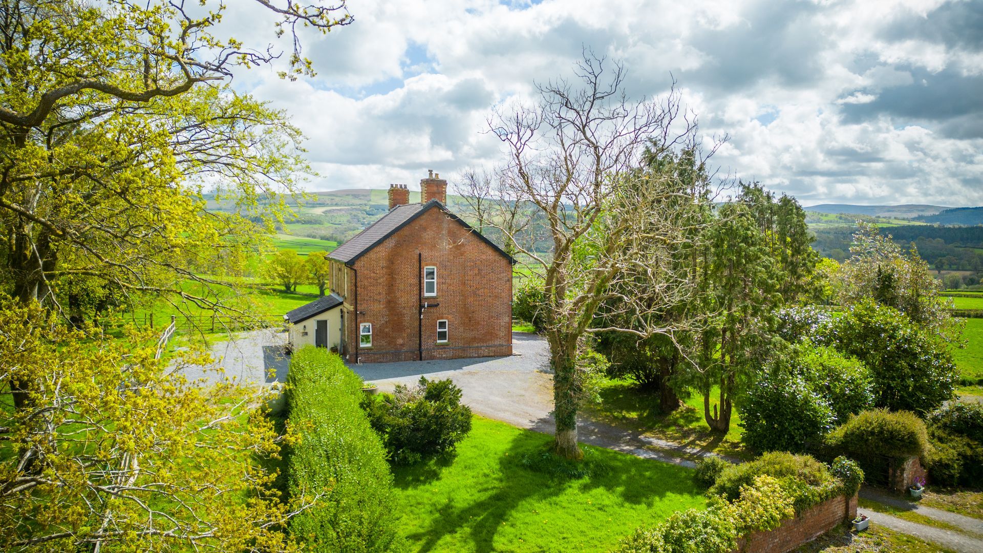 Exterior of The Farmhouse at Green Grove Barns surrounded by gardens and countryside.