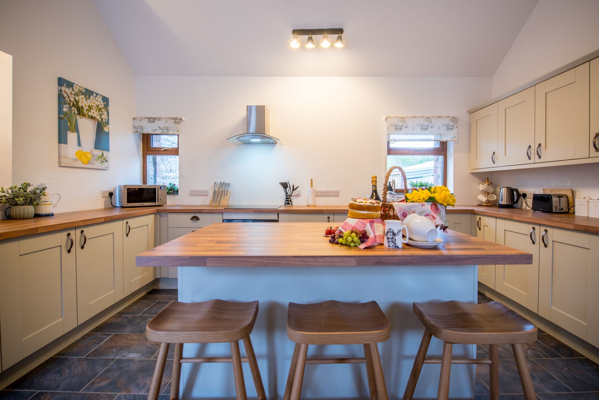 Open-plan kitchen and dining area with breakfast island in The Coach House at Green Grove Barns.