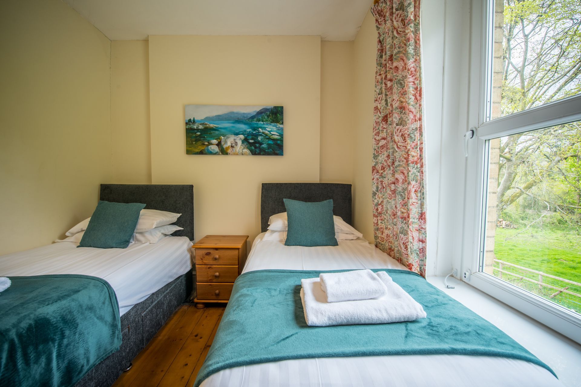 Twin bedroom in The Farmhouse with countryside view and green décor.