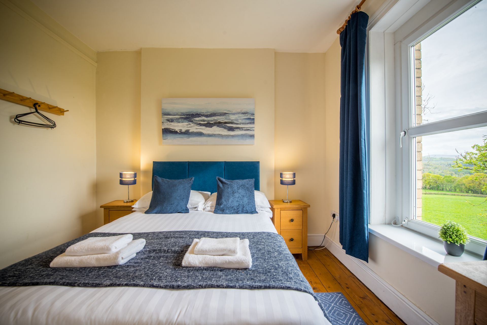 Bright bedroom in The Farmhouse featuring modern artwork and soft lighting.