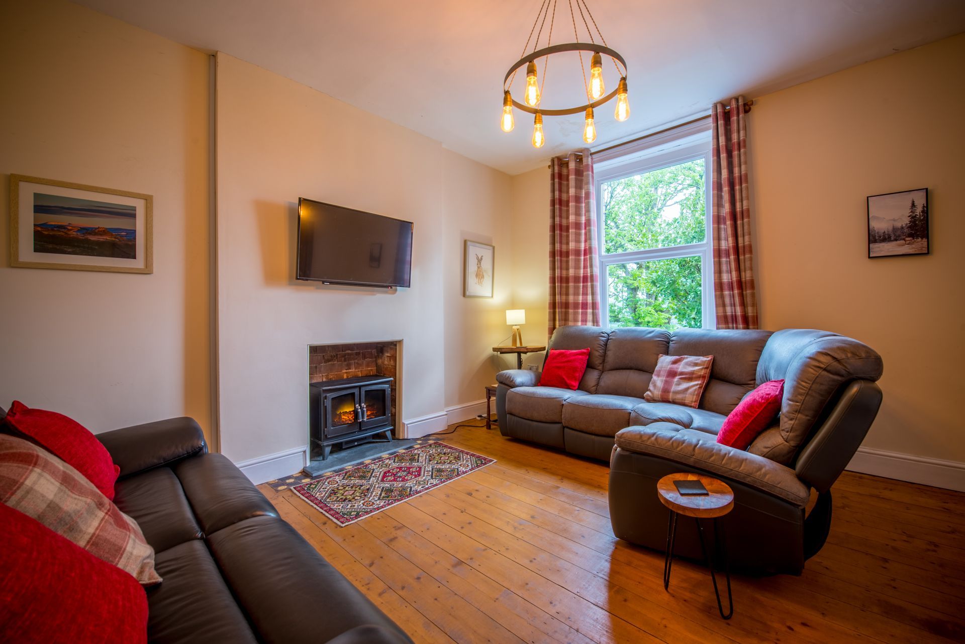 Living room at The Farmhouse with red sofa, wooden beams, and warm lighting.