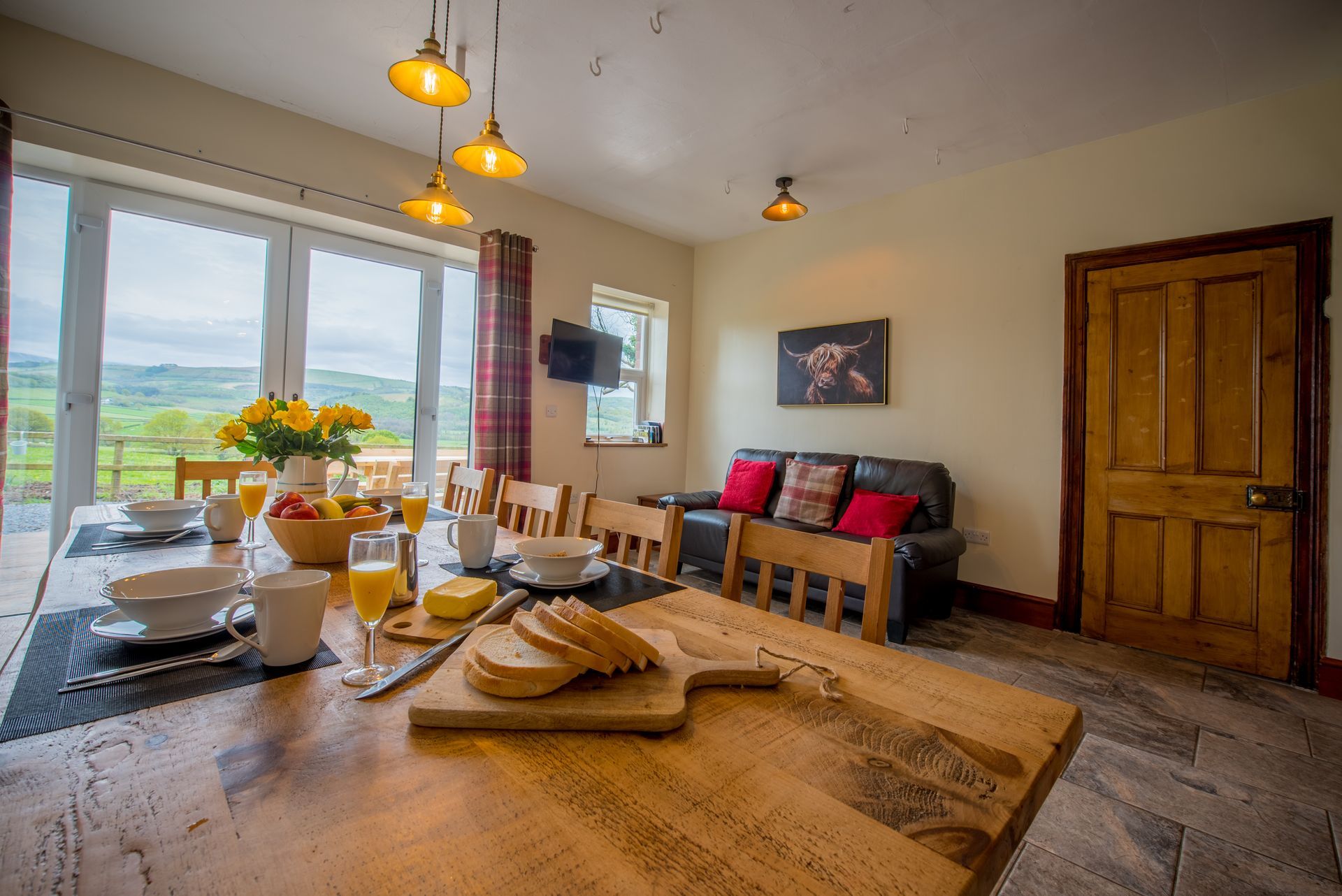 Dining area in The Farmhouse with large wooden table and countryside views.