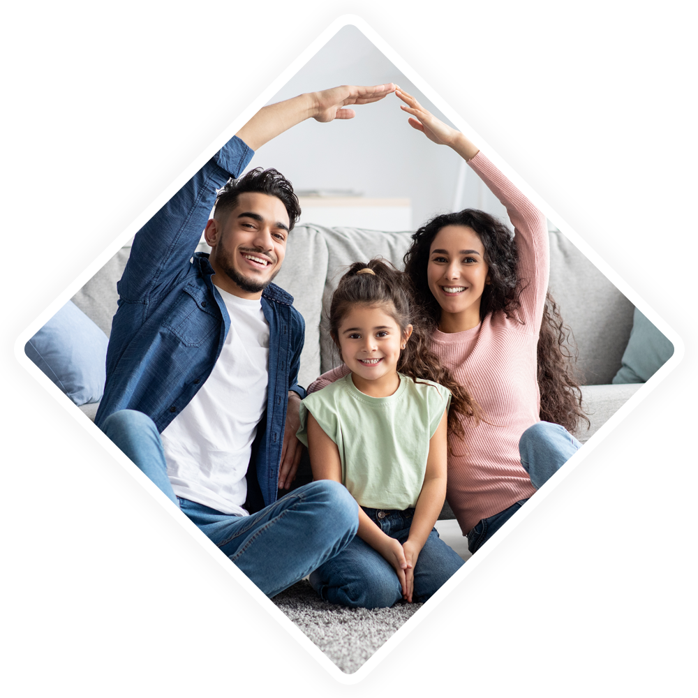 A family is sitting on the floor making a house with their hands.