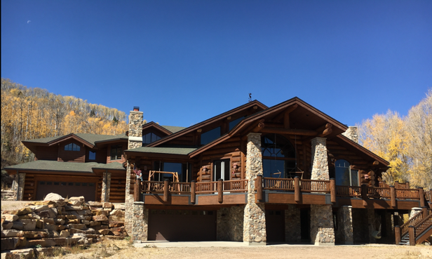A small dog is sitting on a wooden bench.