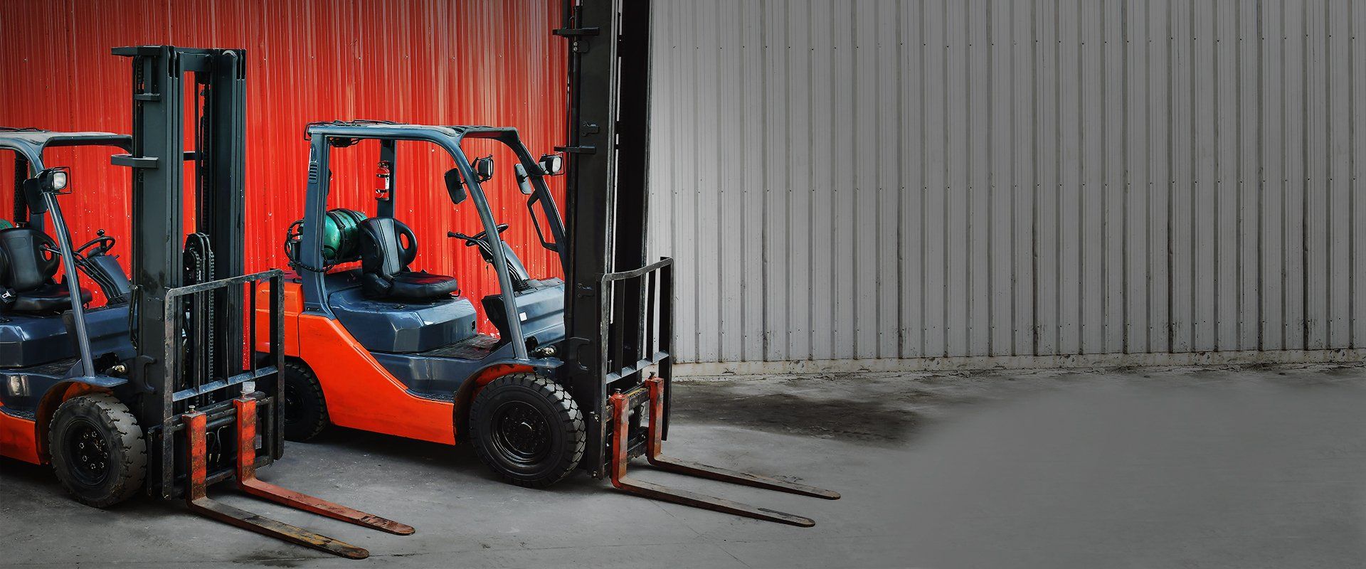 Chariots élévateurs dans un décor d'entrepôt, avec des détails orange et noirs, sur un fond rouge et blanc.
