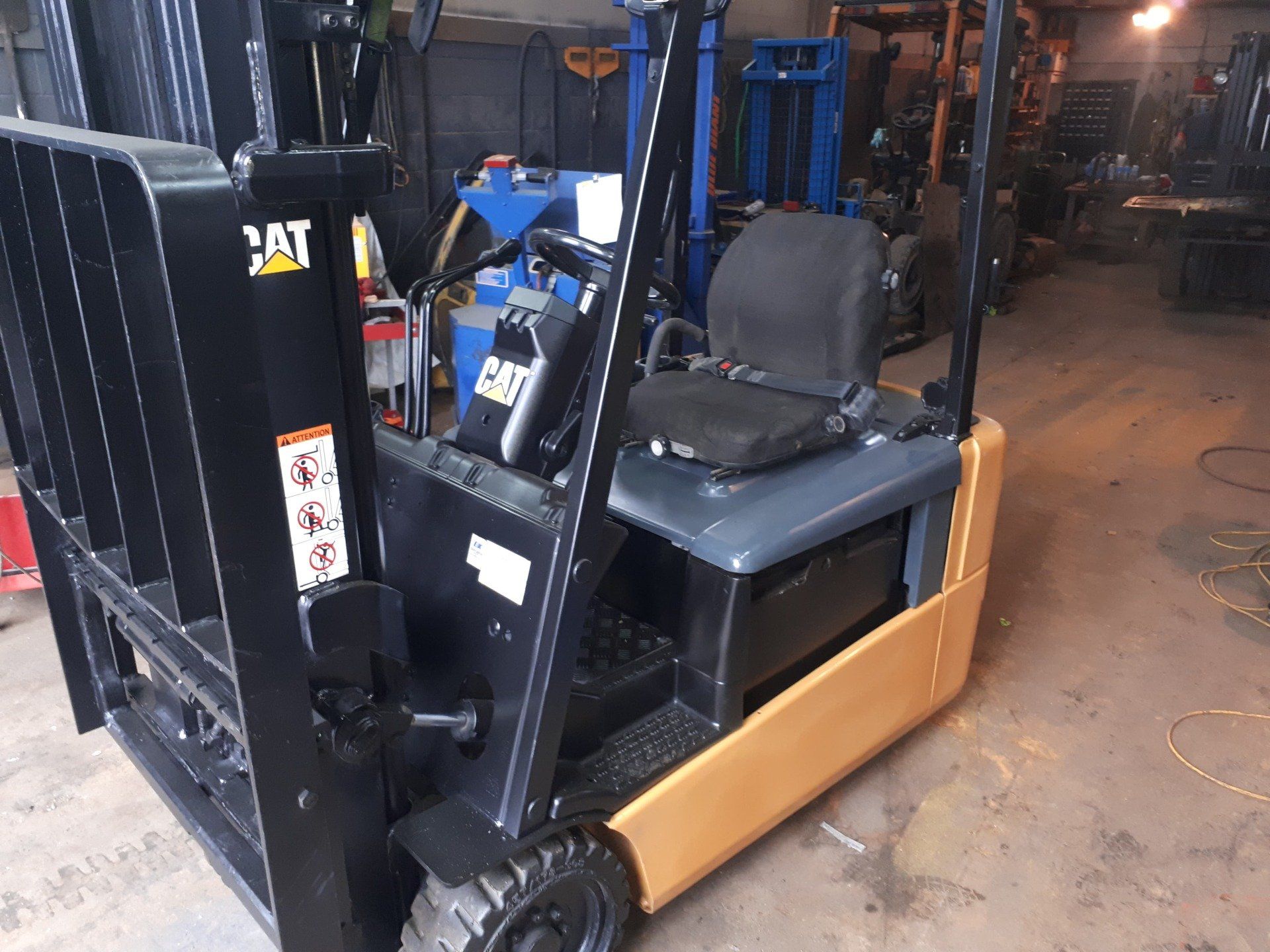 A cat forklift is parked in a garage.