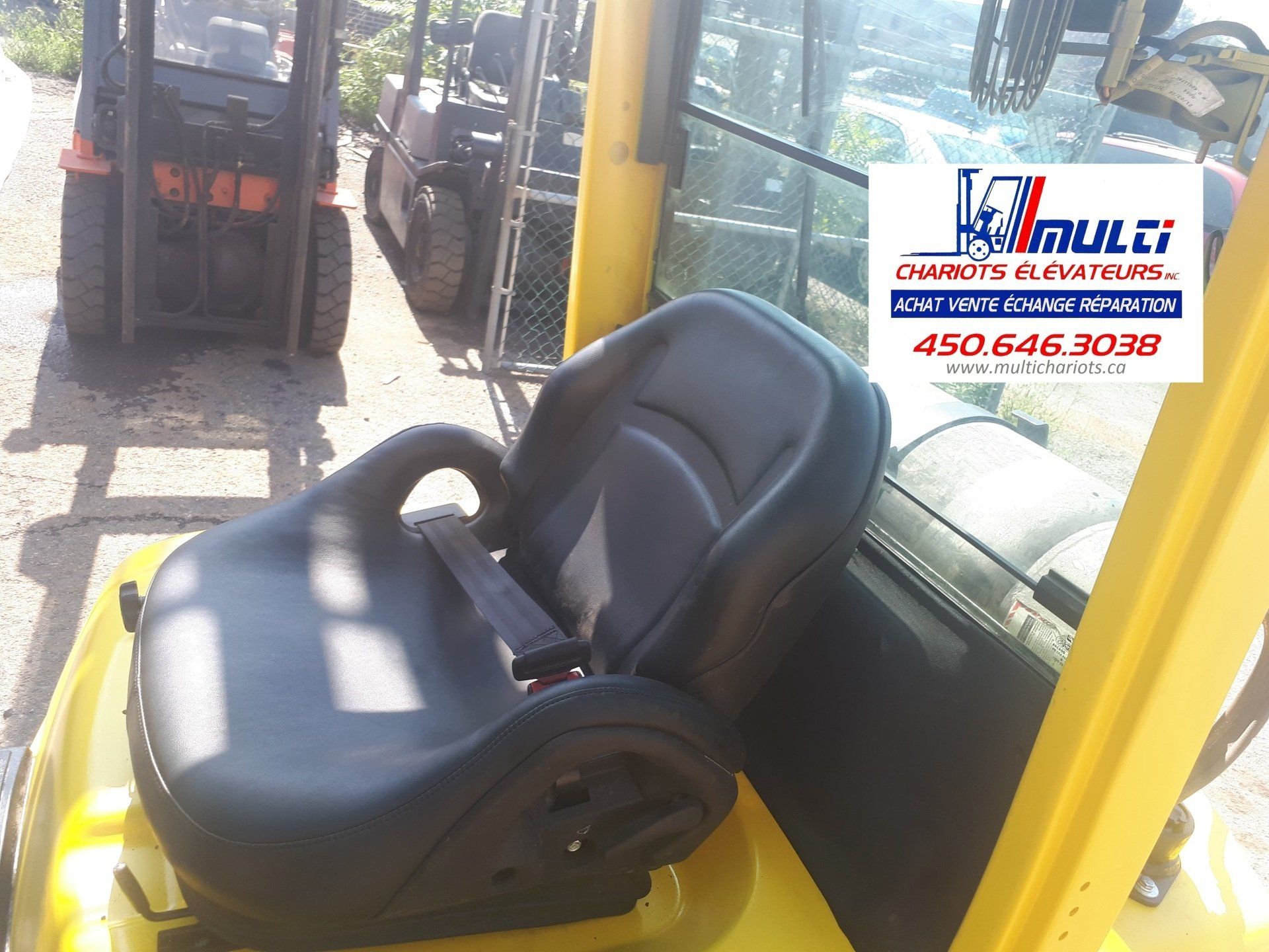 A forklift sits in front of a sign that says multi on it