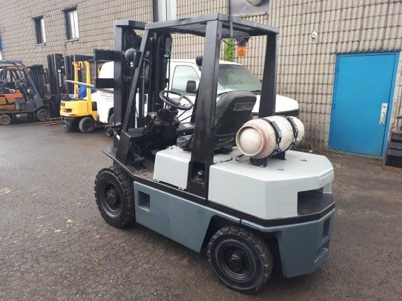 A forklift is parked in front of a building
