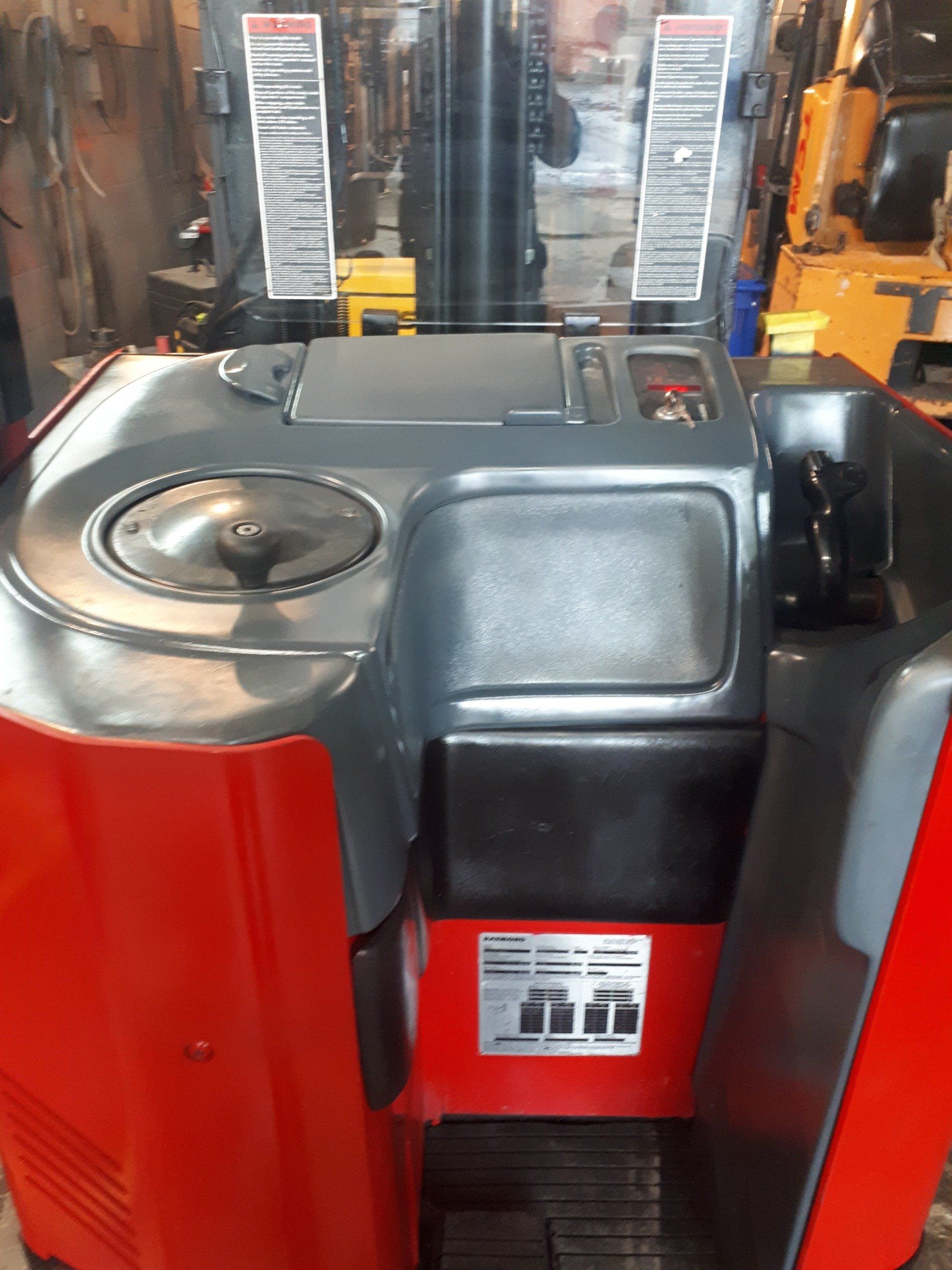A red and black forklift is sitting in a garage