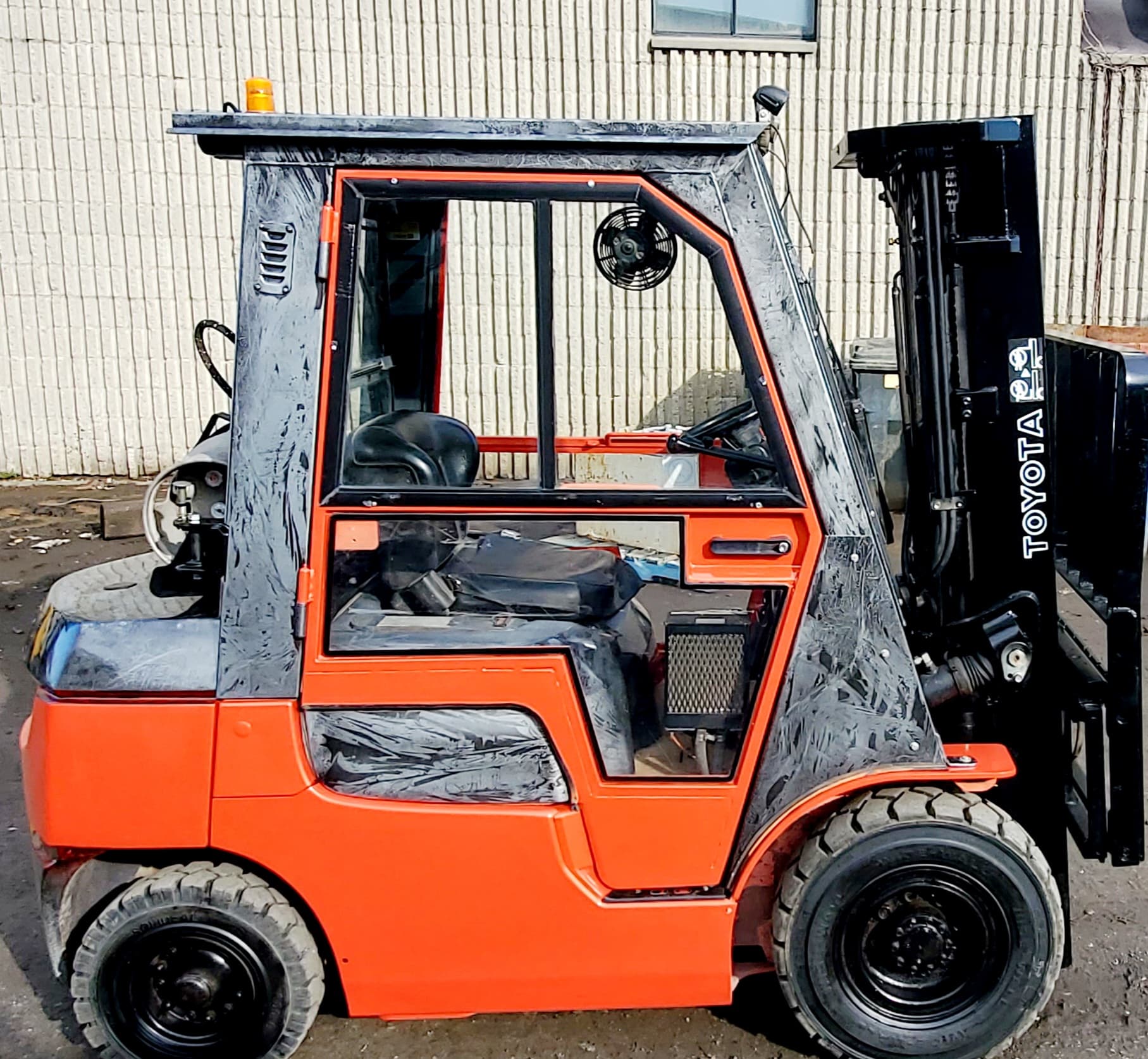 Un chariot élévateur Toyota est garé devant un bâtiment