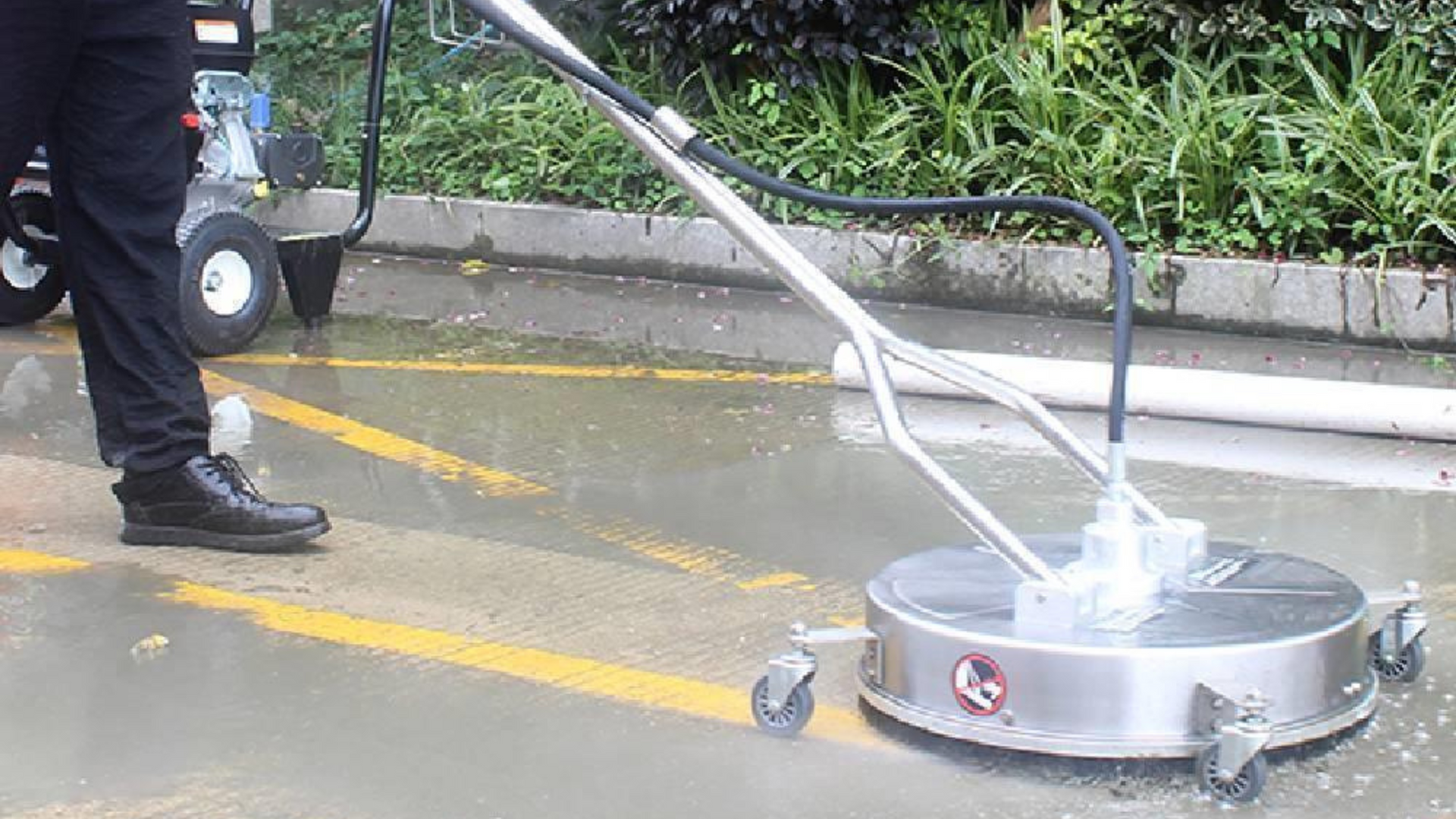 A man is using a machine to clean a parking lot.