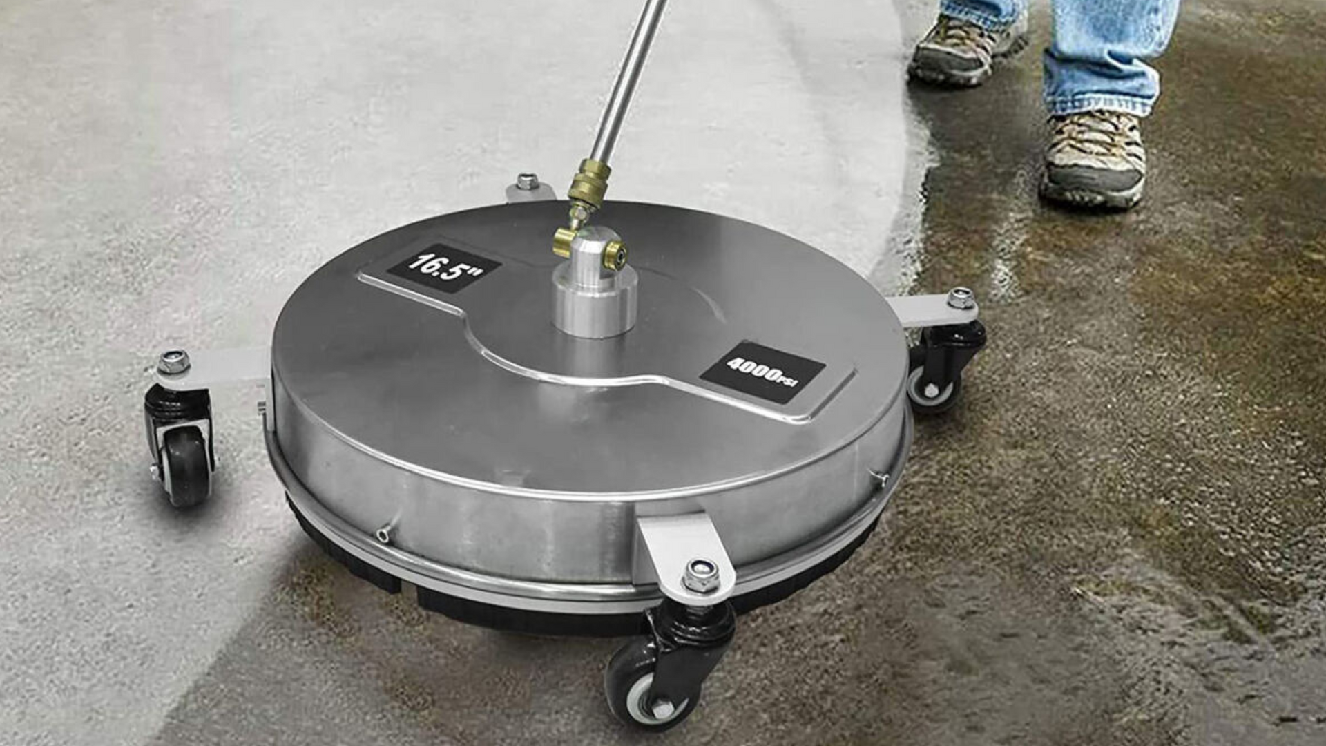 A person is cleaning a concrete floor with a machine.