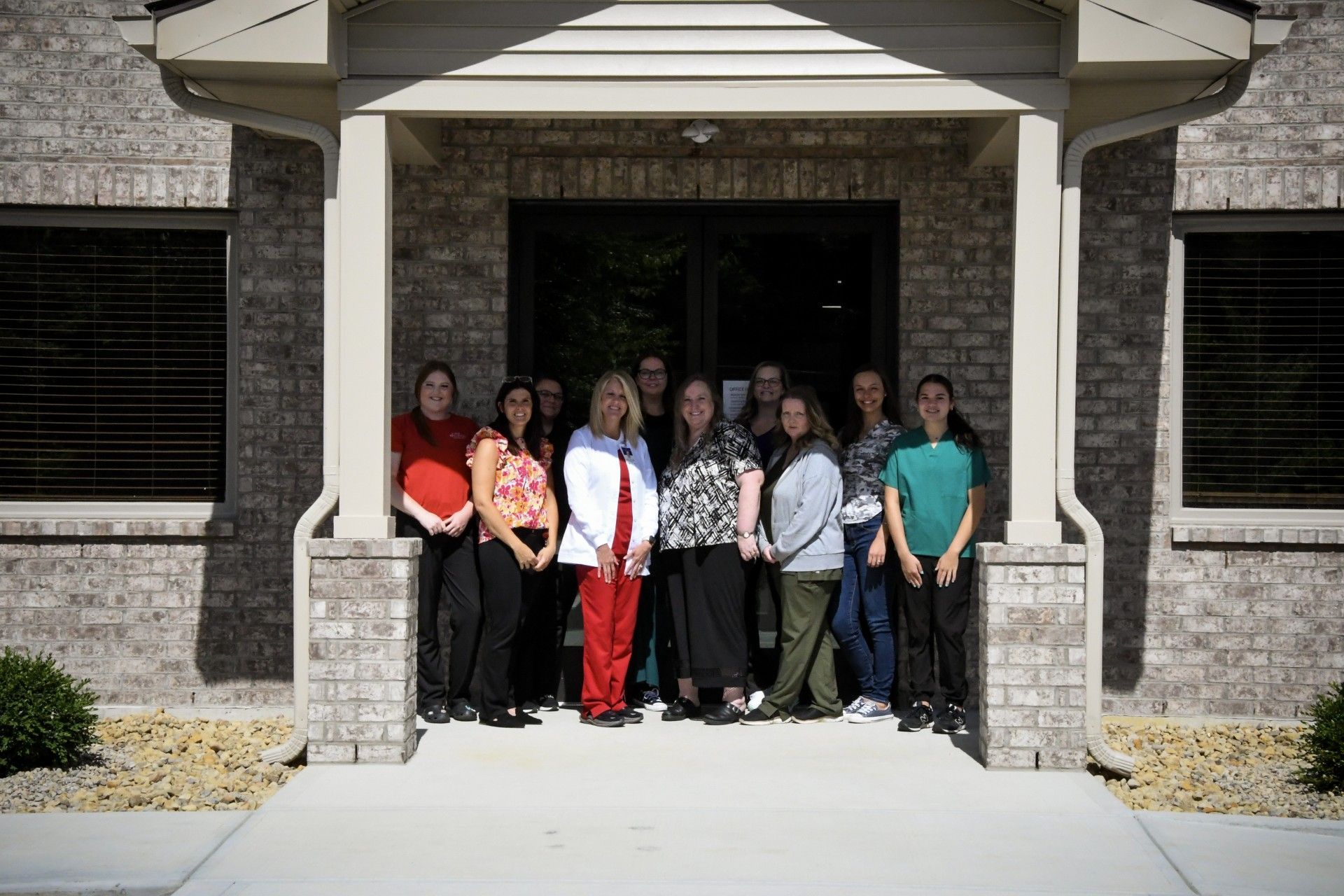 A group of people are posing for a picture in front of a brick building.