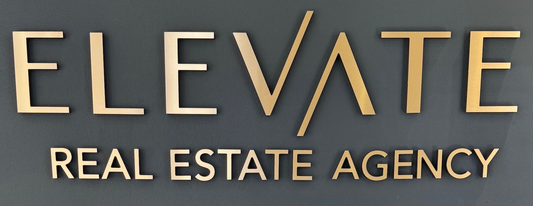 Logo for Elevate Real Estate Agency featuring the brand name in black with a stylized 'A' background.