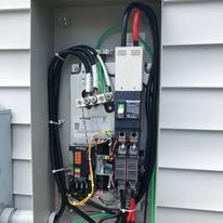 A close up of a electrical box with a lot of wires coming out of it.