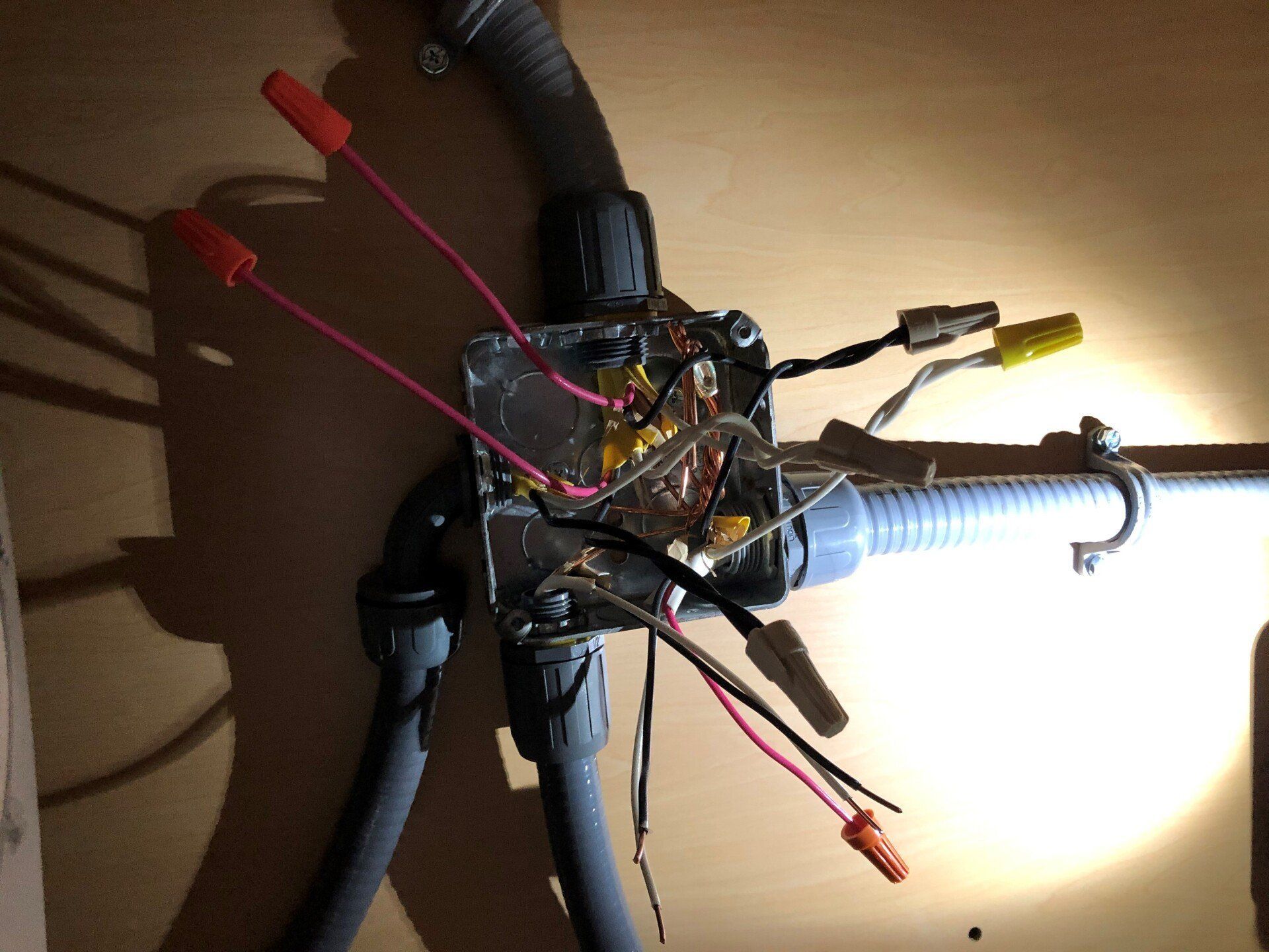 A bunch of wires are connected to a box on a wall