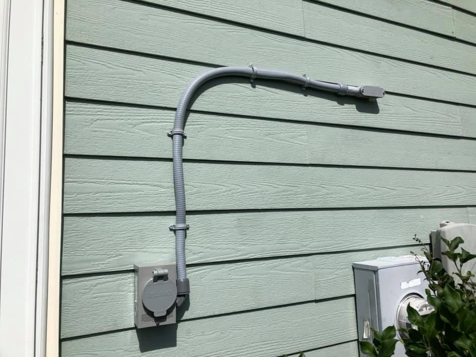 A electrical outlet on the side of a house.