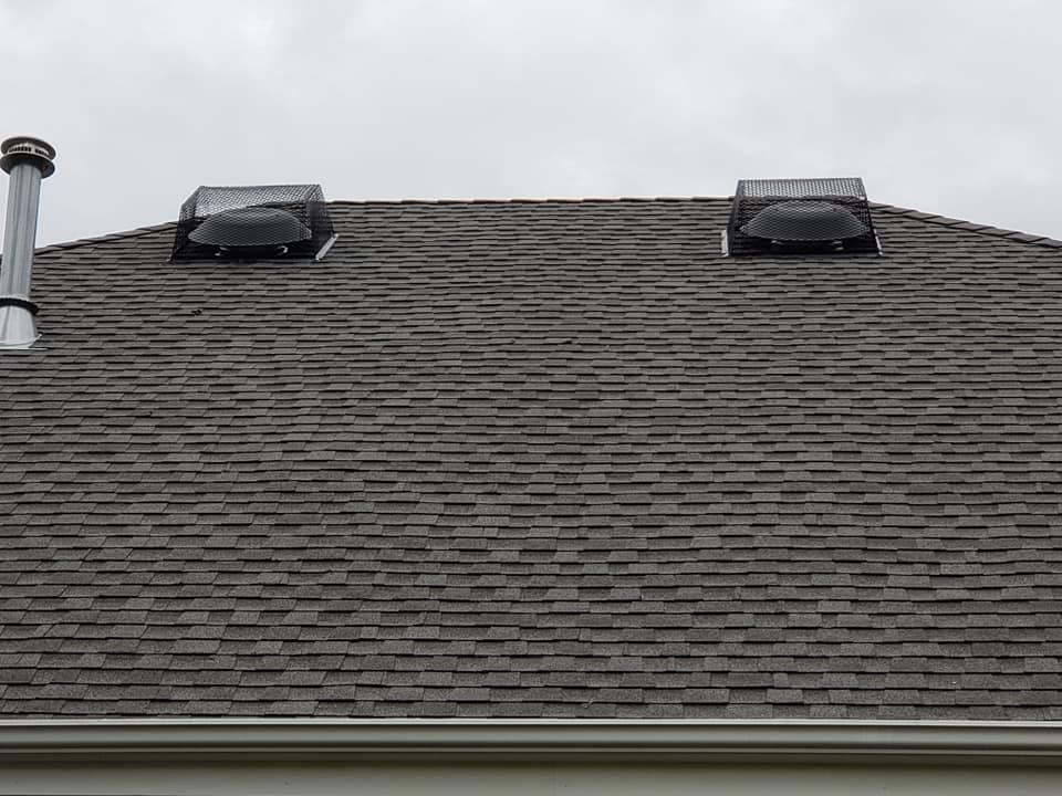 A close up of a roof with two vents on it.