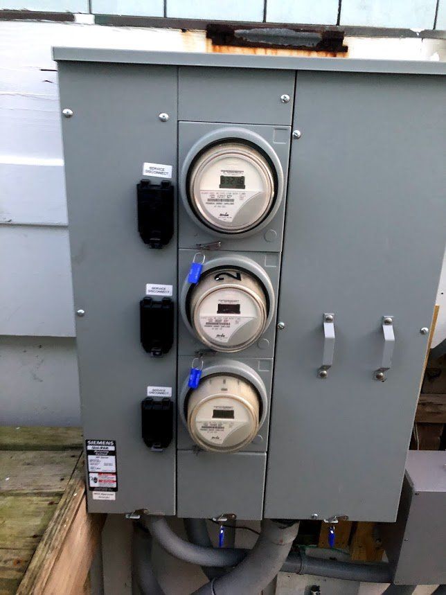 A close up of a electrical box with three electrical meters on it.