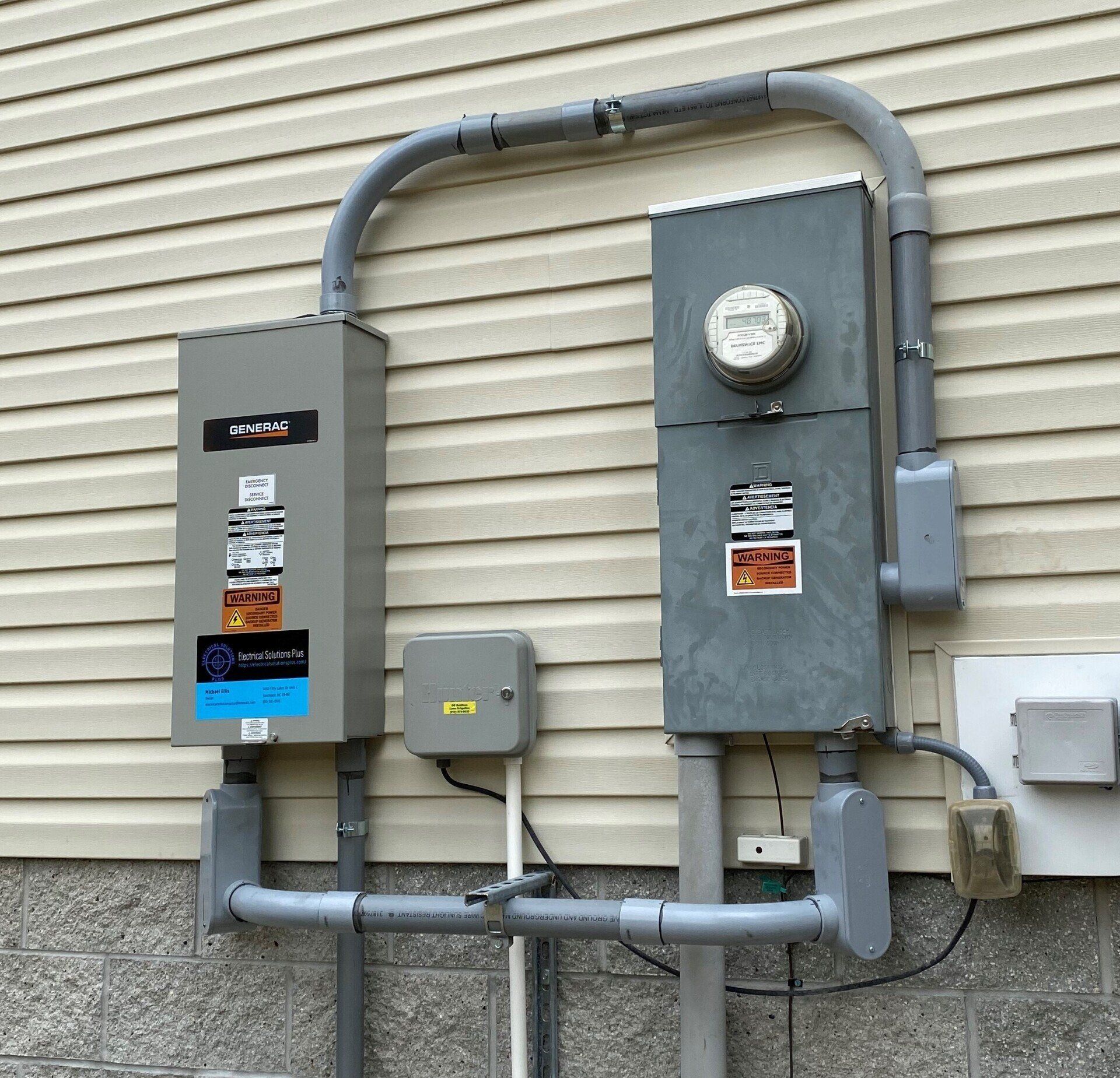 An electrical box on the side of a building with a meter on it