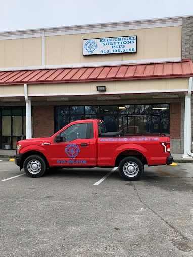 A red truck is parked in front of a building.