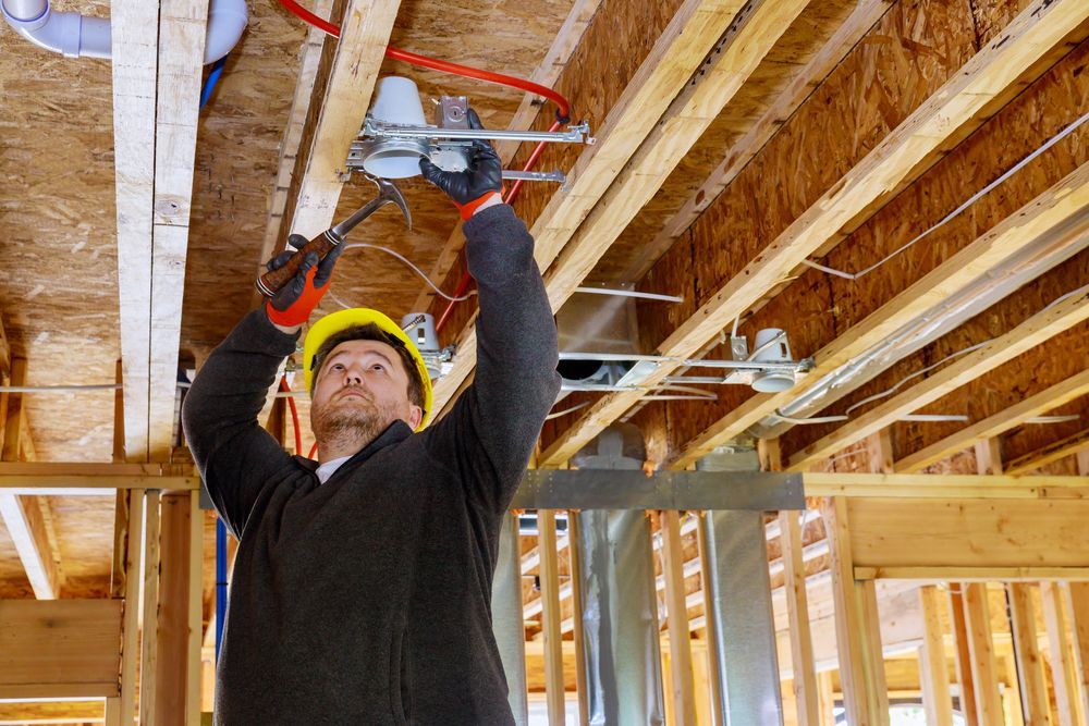 A man is working on the ceiling of a house under construction.