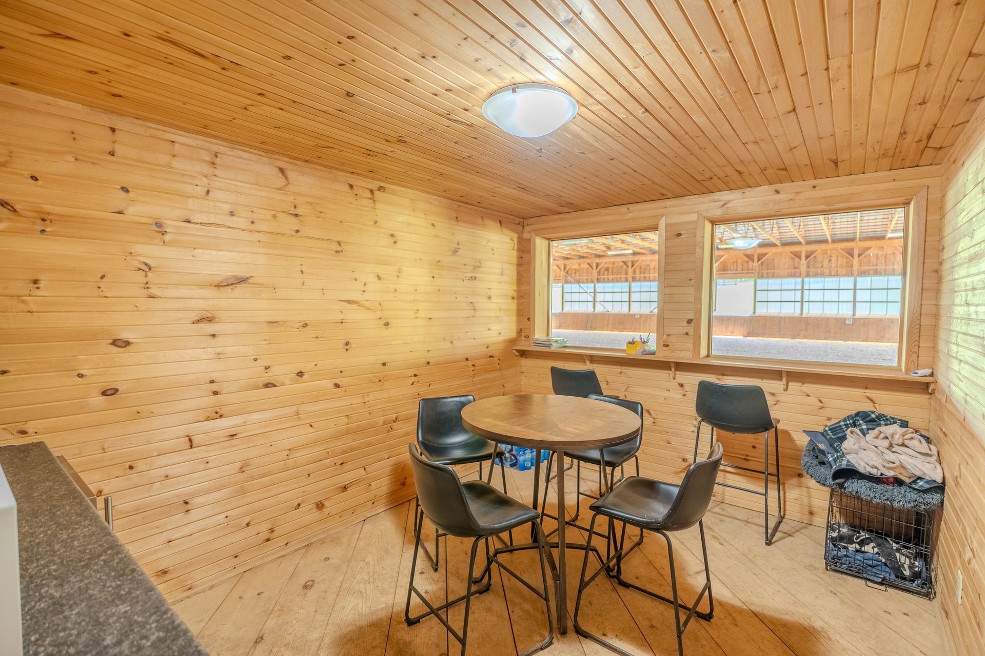 A wooden room with a table and chairs in it.