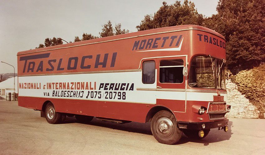 Camion da trasloco d'epoca rosso e bianco con la scritta 