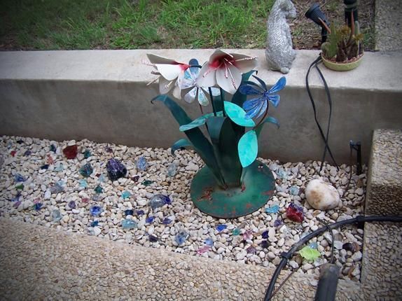 A garden with a statue of a bird and flowers
