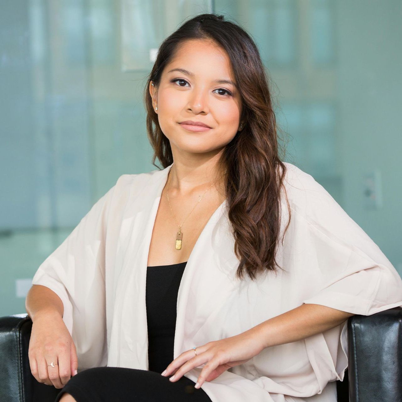 A woman in a white cardigan is sitting in a chair