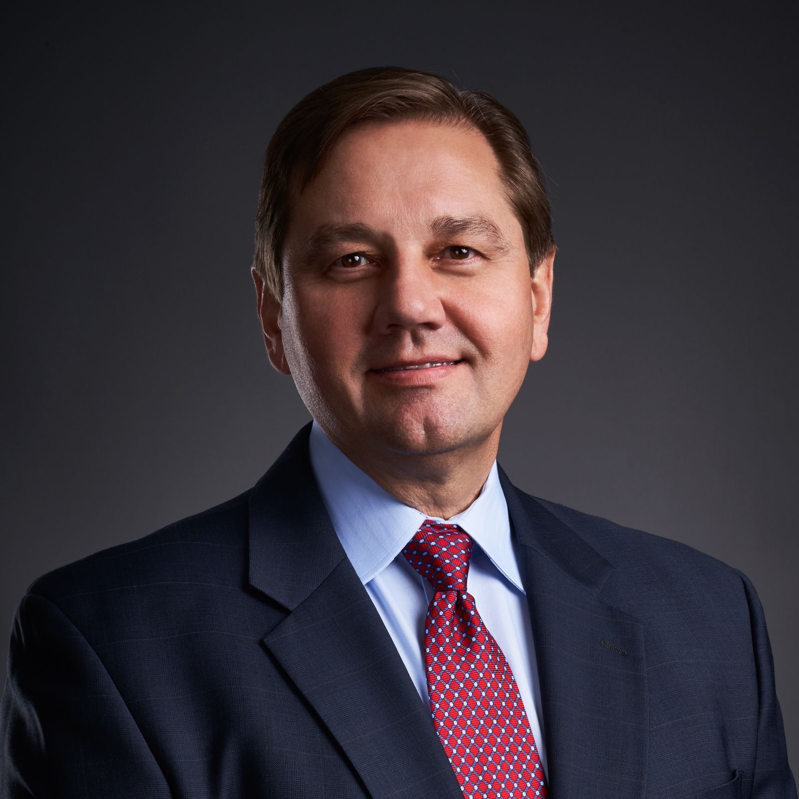 A man in a suit and tie is smiling for the camera.