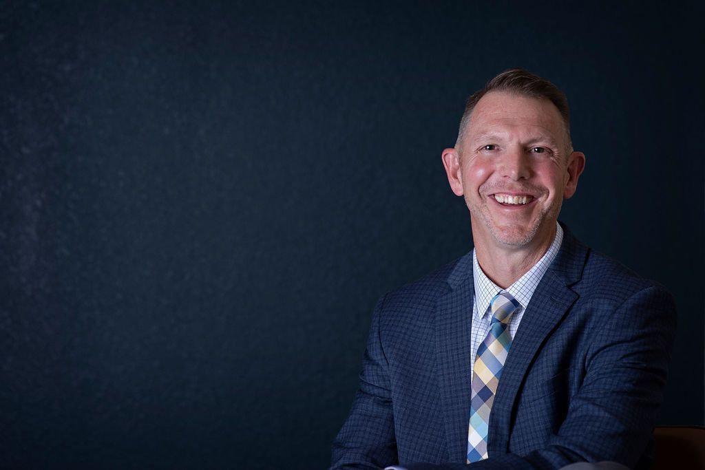 A man in a suit and tie is smiling for the camera.
