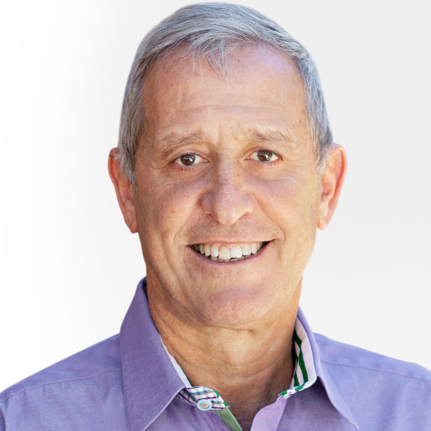 A man in a purple shirt is smiling for the camera.