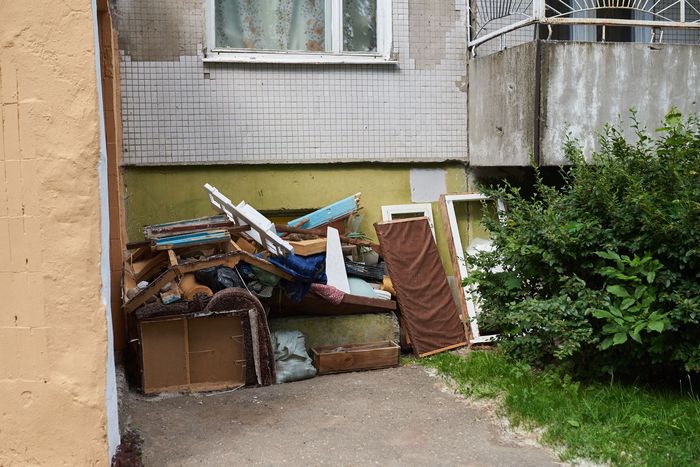 A large pile of rubbish under the Windows of a house