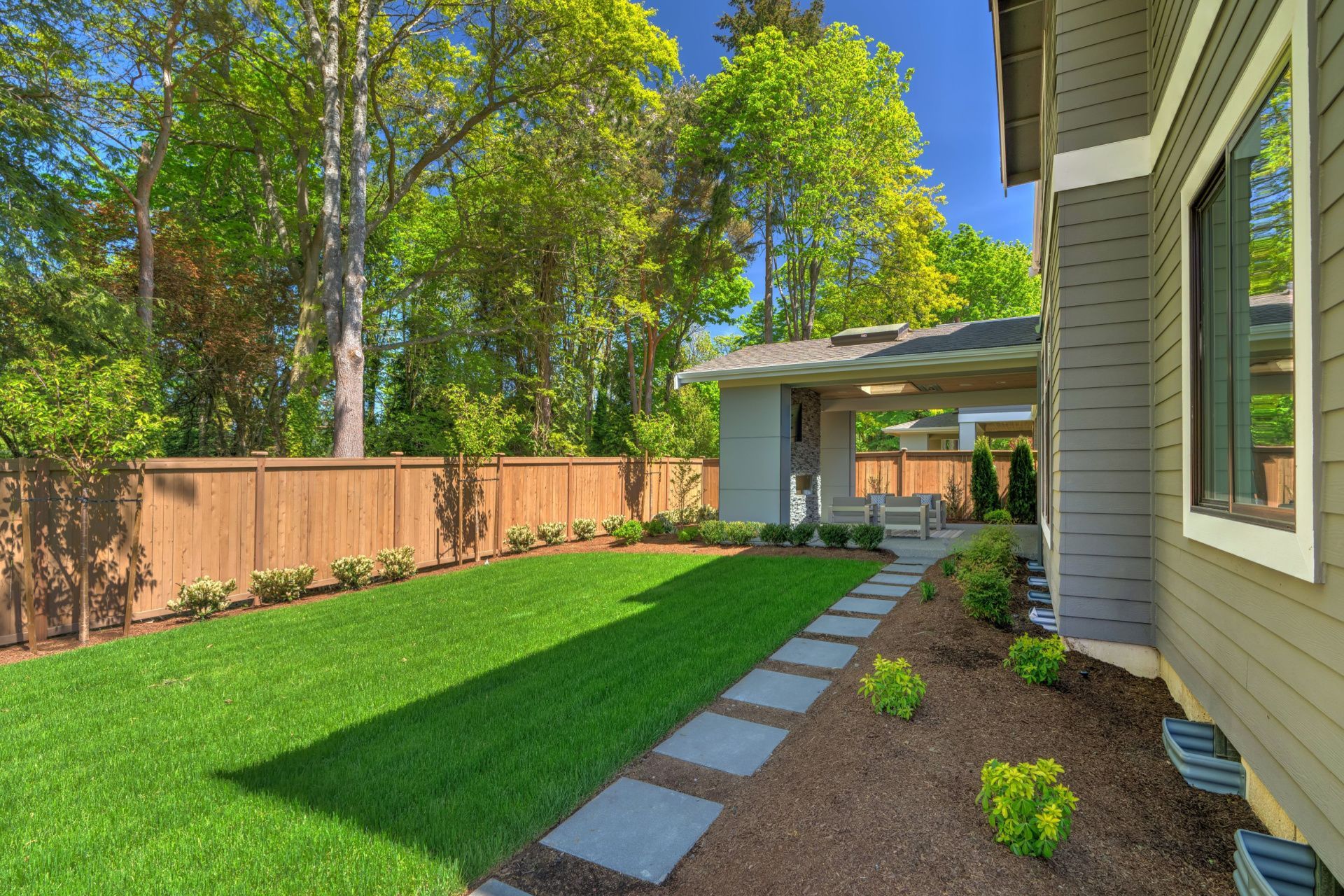 a house with a lush green lawn and a wooden fence