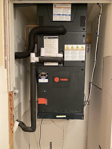 a trane air conditioner is hanging on a wall in a room .