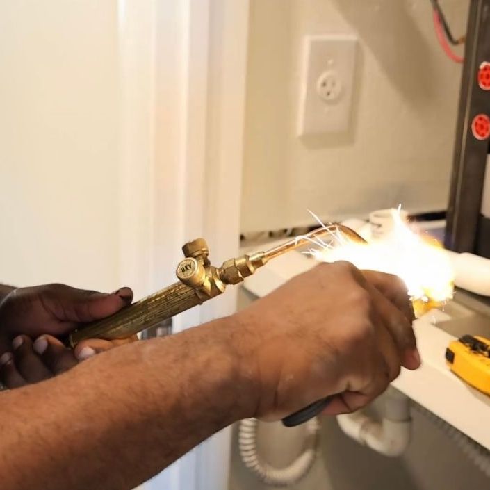 a man is working on a pipe with a torch