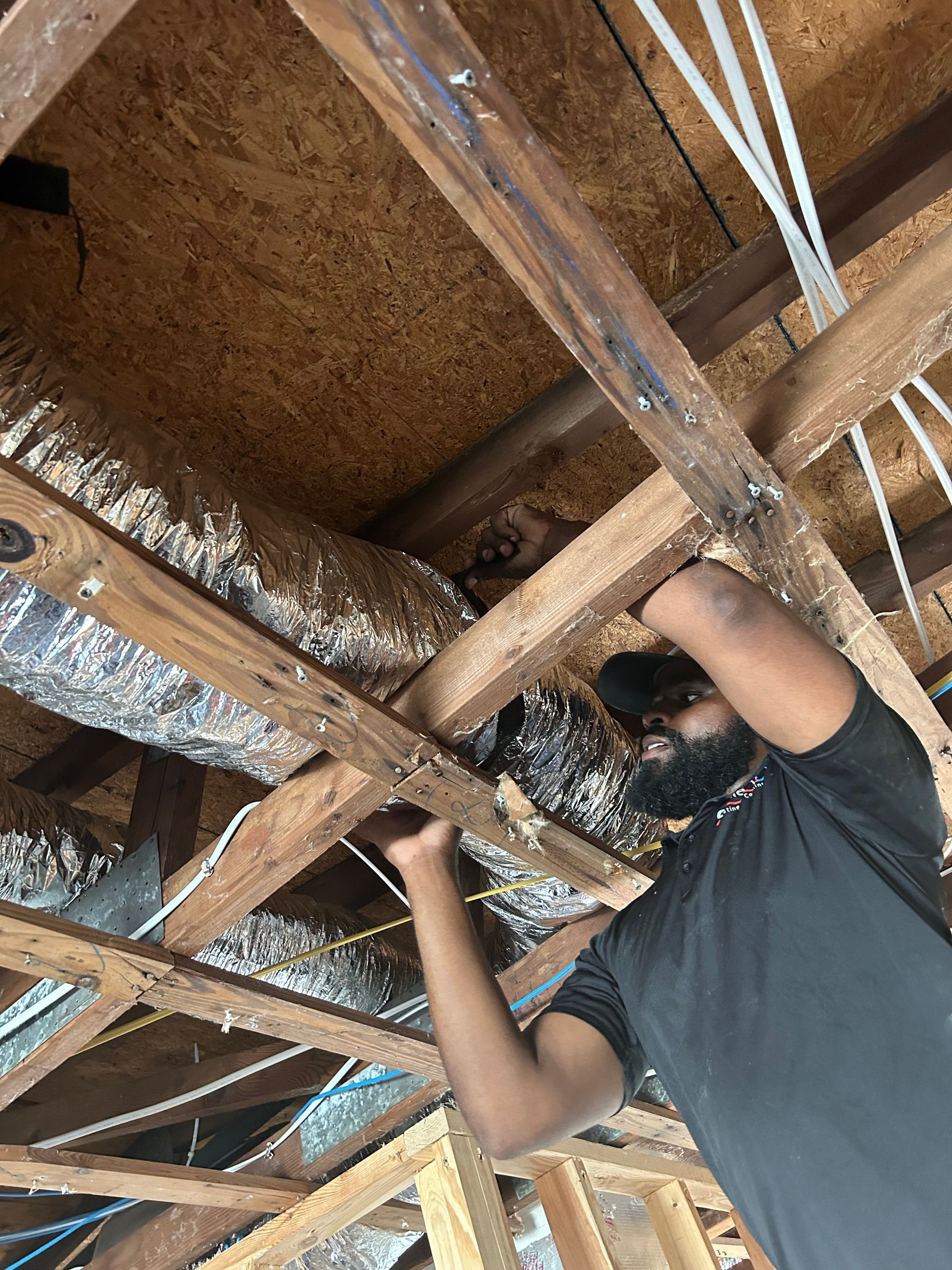 a man is working on the ceiling of a house under construction .