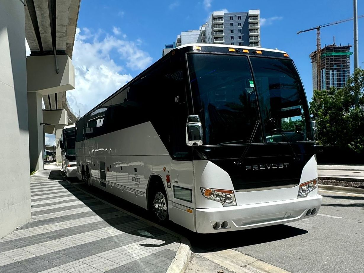 A large white and black bus is parked on the side of the road.