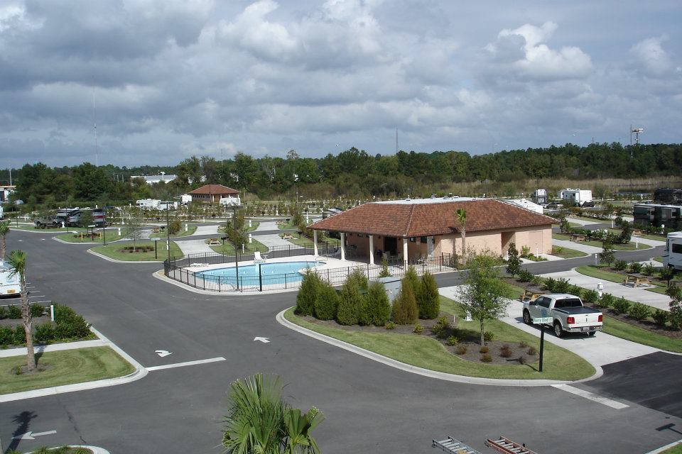arial photo of paved roads and pavilion with swimming pool