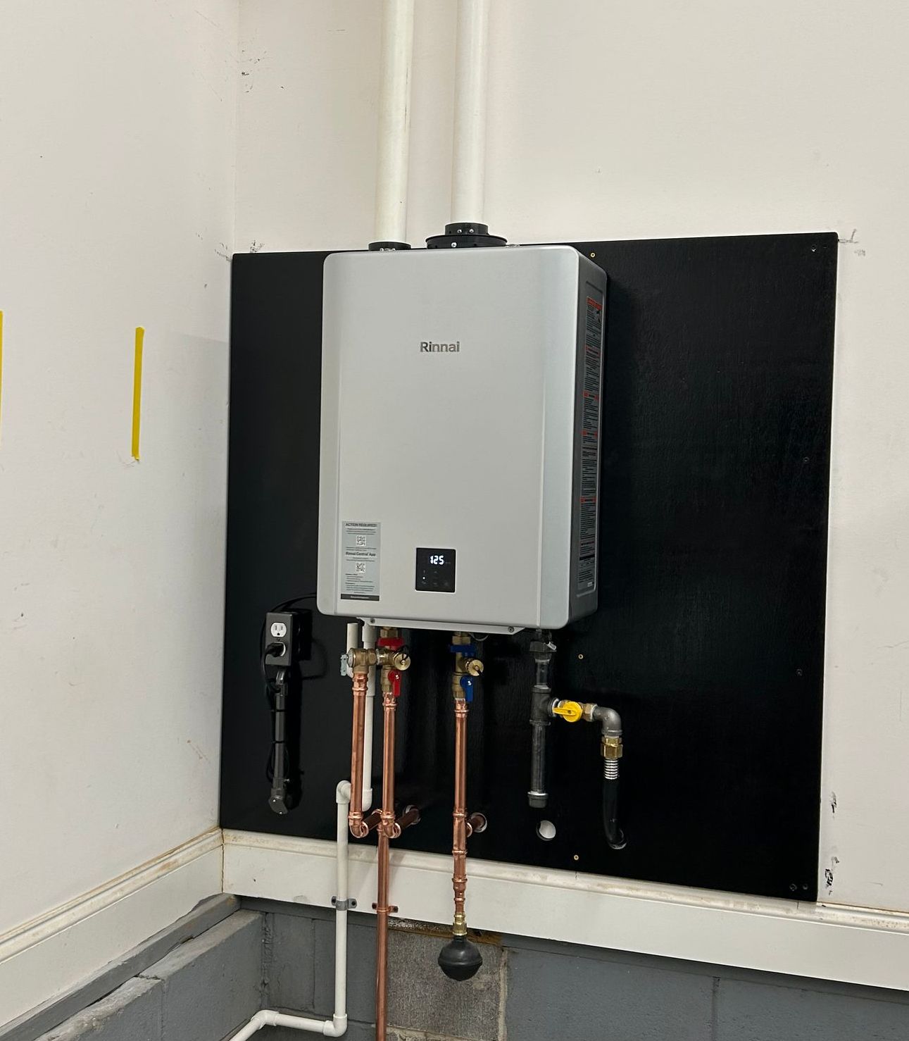 A water heater is hanging on a wall in a room.