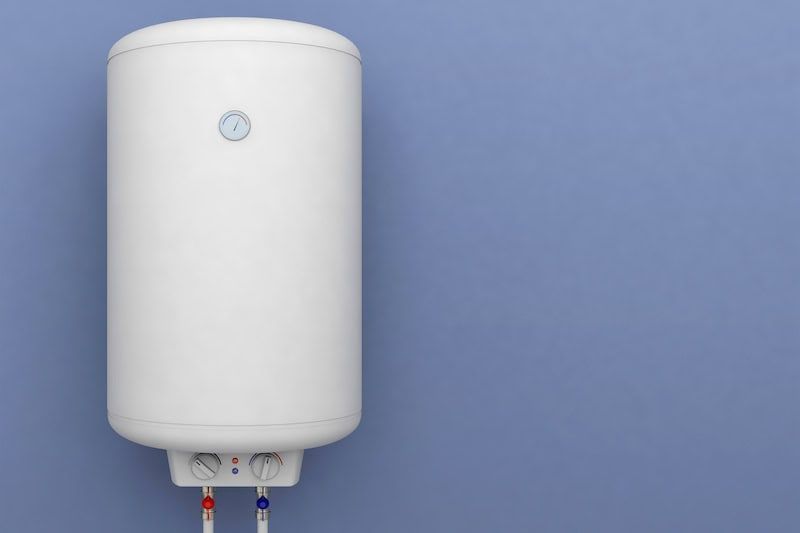 A white water heater is hanging on a blue wall.