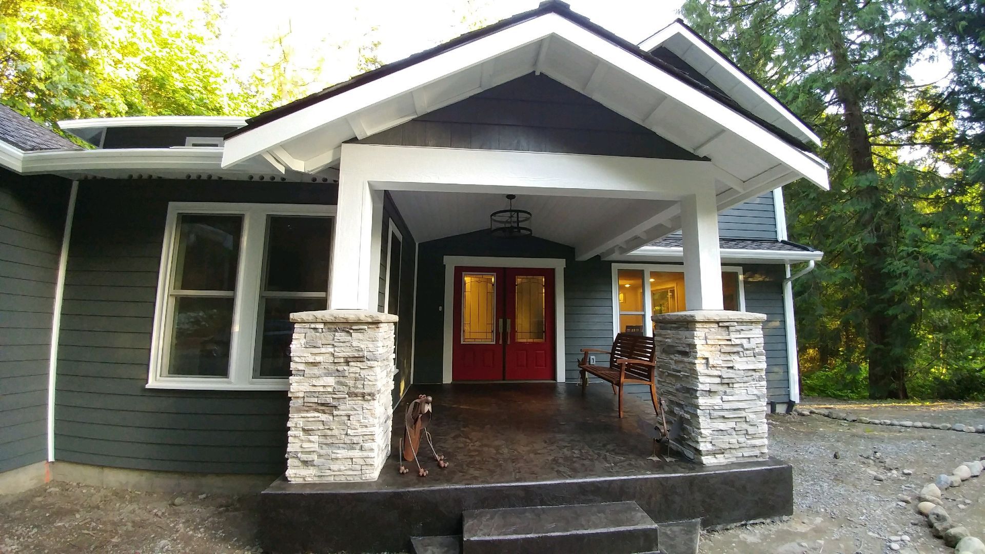 Front porch with stone columns and red double doors.