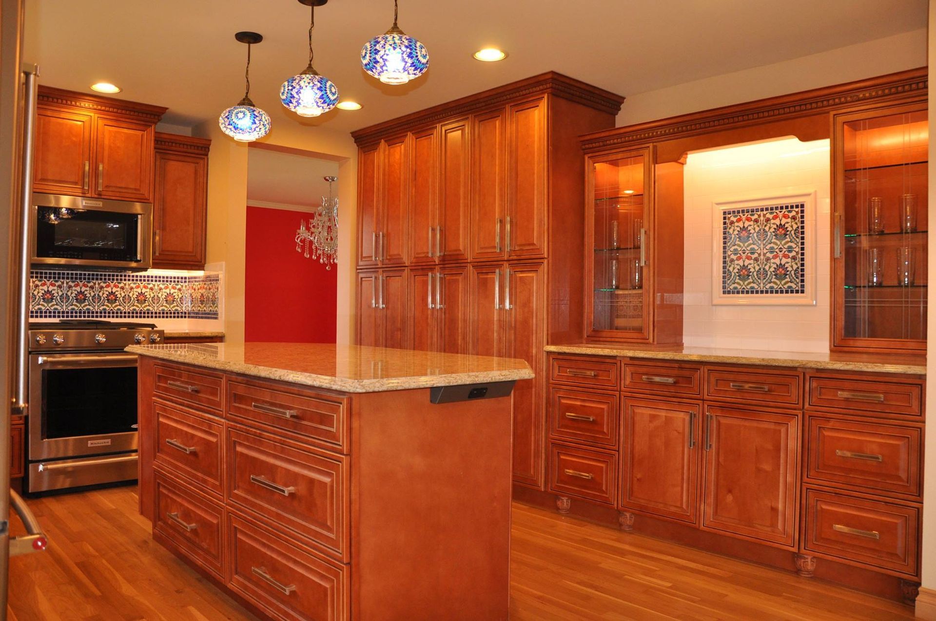 Kitchen with wooden cabinets, island, and stainless steel appliances; red accent wall.