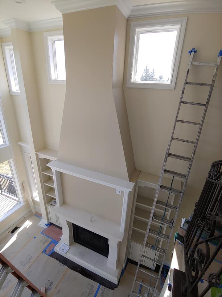 High-angle view of a tall fireplace with shelves, white mantel, and ladder leaning against the wall.