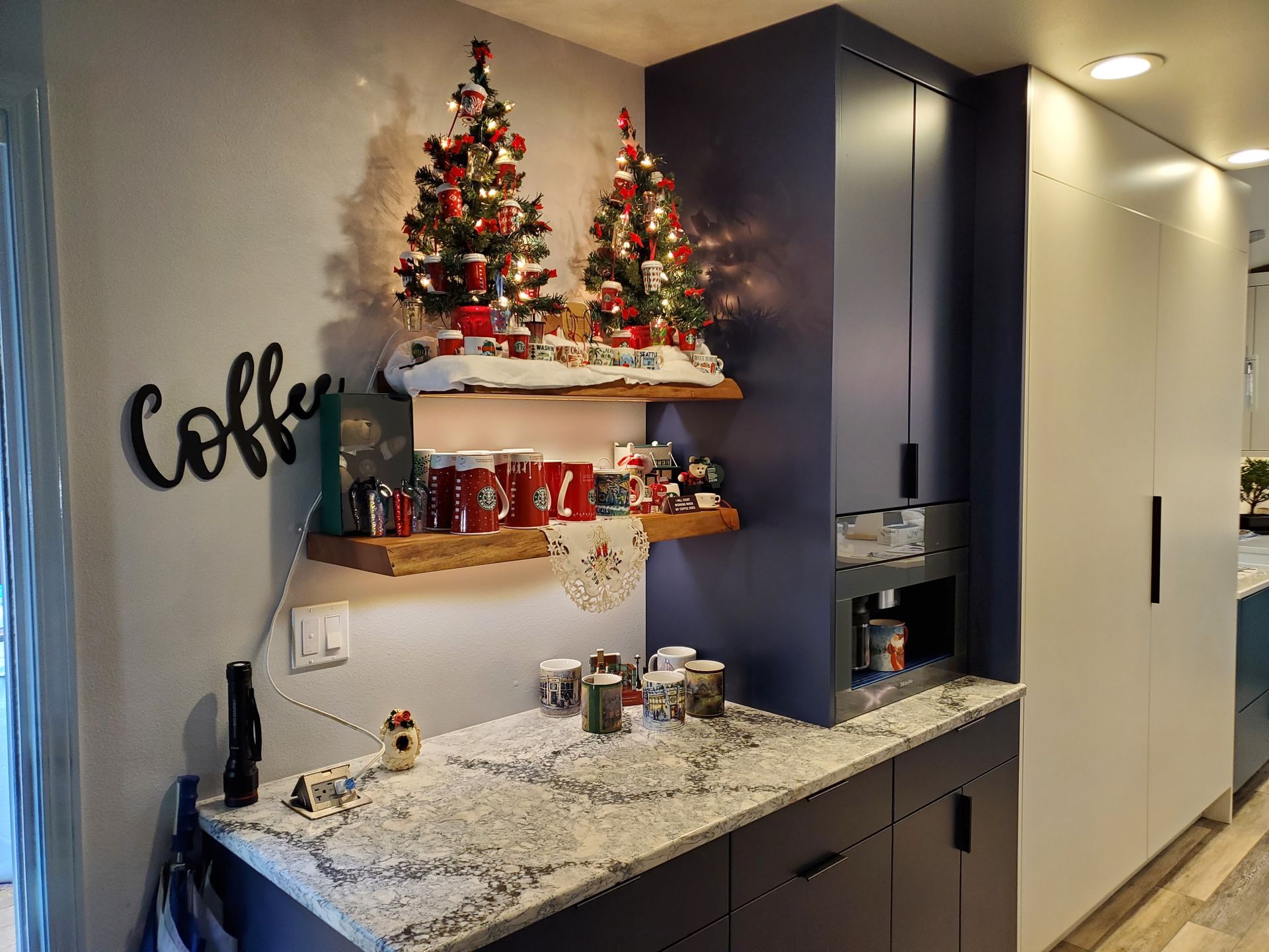 A coffee bar decorated for Christmas with blue cabinets, granite countertop,