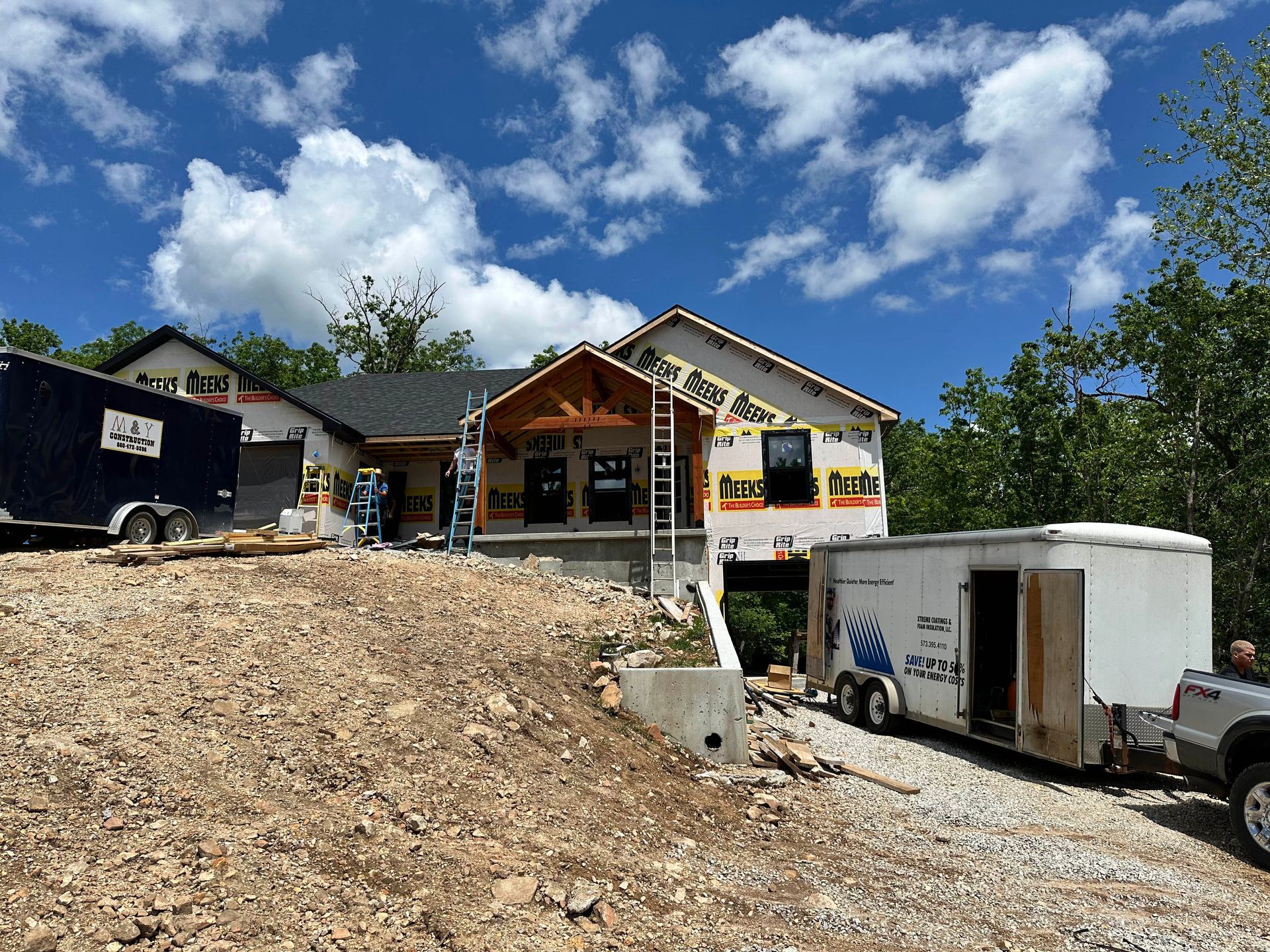 A truck is parked in front of a house under construction.