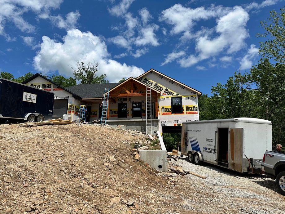 A truck is parked in front of a house under construction.